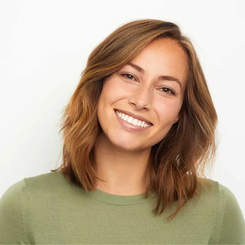 A woman in a green shirt with a beautiful smile.