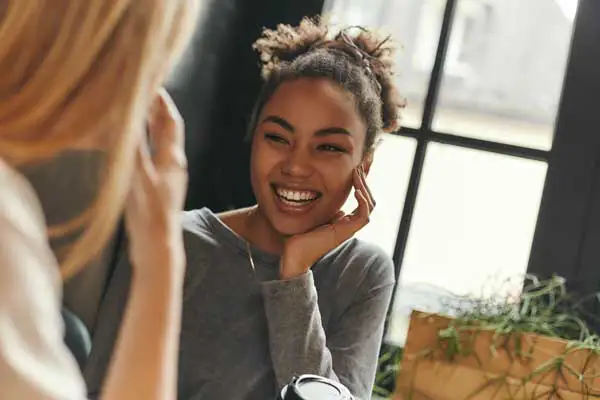 two women talking and smiling.